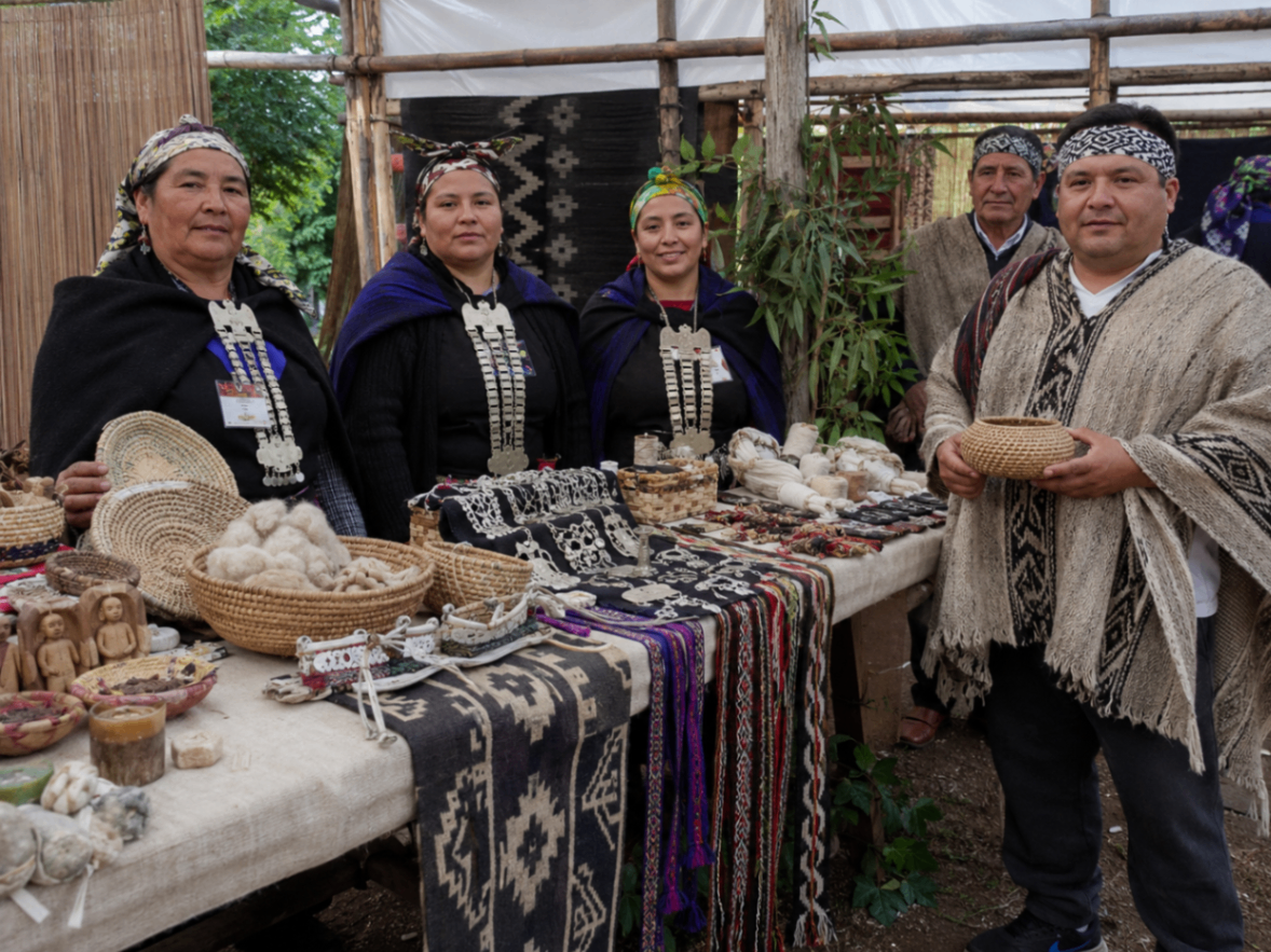 Familia de economía indígena exhibiendo artesanías, textiles y cestería tradicional.